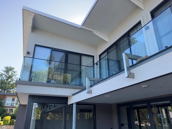 Frameless glass balustrade along the upstairs balcony of a modern two-storey home