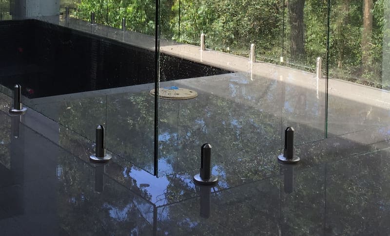 Close view of stainless spigots holding frameless glass panels